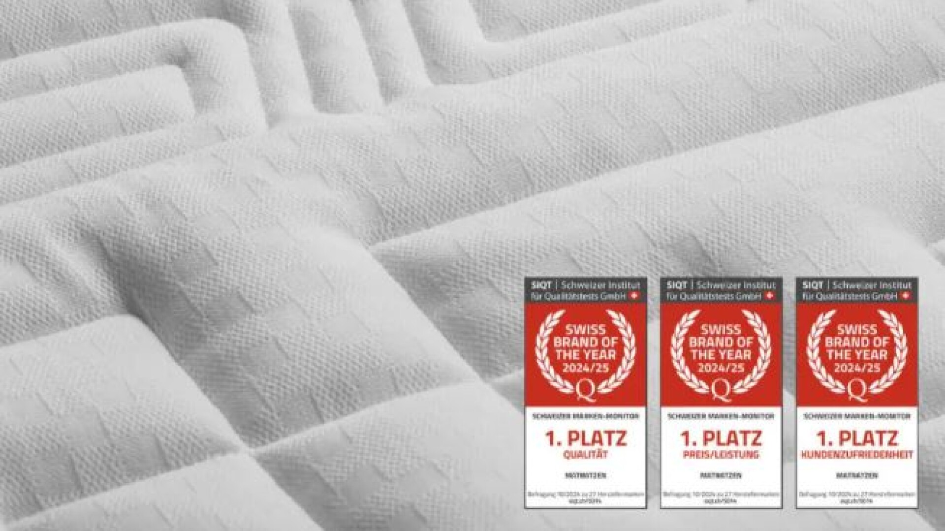 Nahaufnahme einer weissen Matratze mit geometrischem Stickmuster. Drei Auszeichnungen in der unteren rechten Ecke zeigen rote Logos der Schweizer Marke des Jahres 2023/24 und deutschen Text zu den ersten Plätzen.
