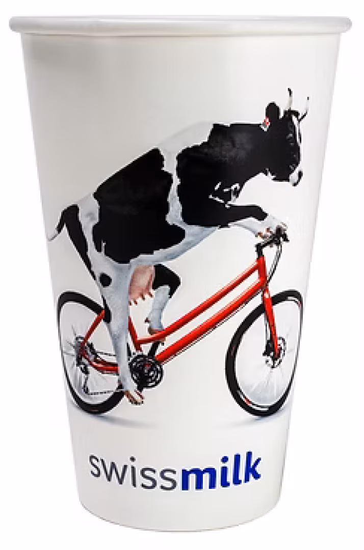 Une vache sur un vélo rouge est représentée sur un gobelet blanc, avec le texte swissmilk en bas.